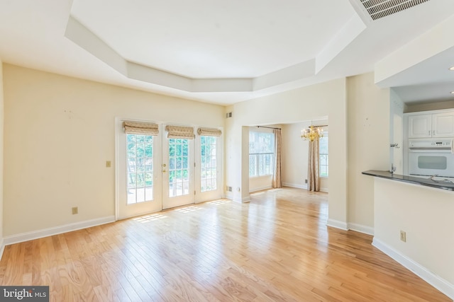 2 Larch Way, Princeton, NJ 08540 - unfurnished living room featuring a chandelier, a raised ceiling, and light wood finished floors