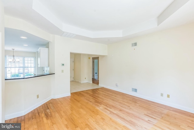 2 Larch Way, Princeton, NJ 08540 - spare room featuring light wood-style floors, a tray ceiling, and a chandelier