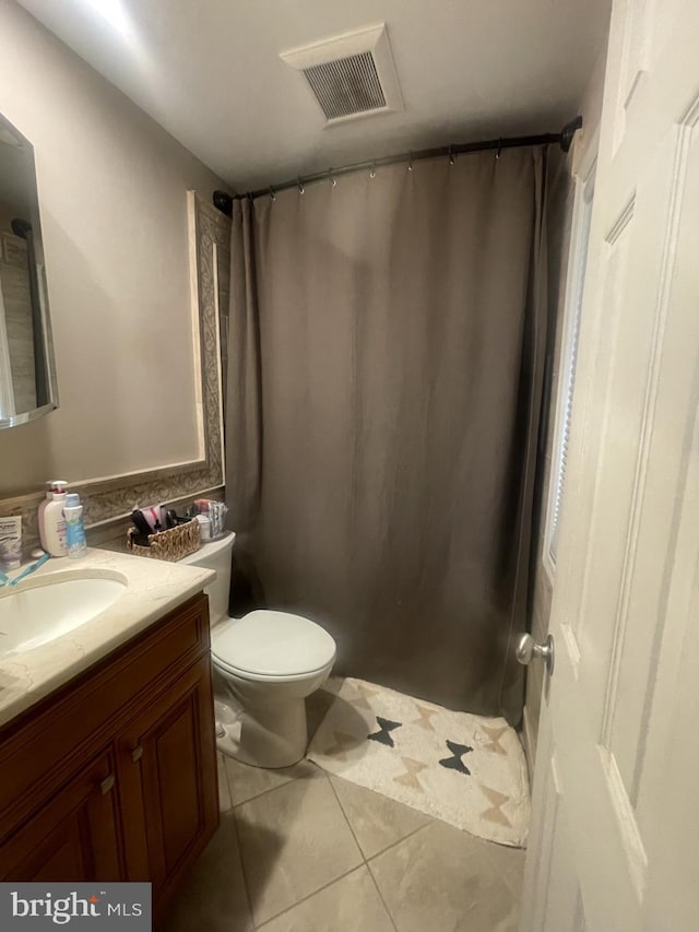 full bathroom with tile patterned floors, vanity, toilet, and curtained shower