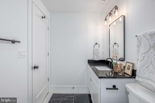 426 Manor Pl NW Unit 1, Washington, DC 20010 - bathroom featuring marble look tile flooring, baseboards, toilet, and vanity