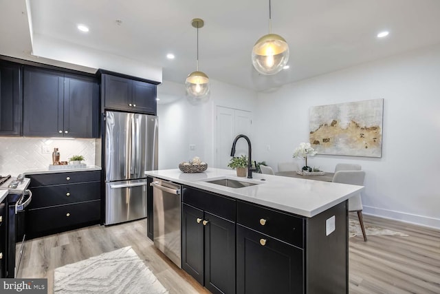 426 Manor Pl NW Unit 1, Washington, DC 20010 - kitchen featuring stainless steel appliances, a sink, light wood-style floors, light countertops, and decorative backsplash
