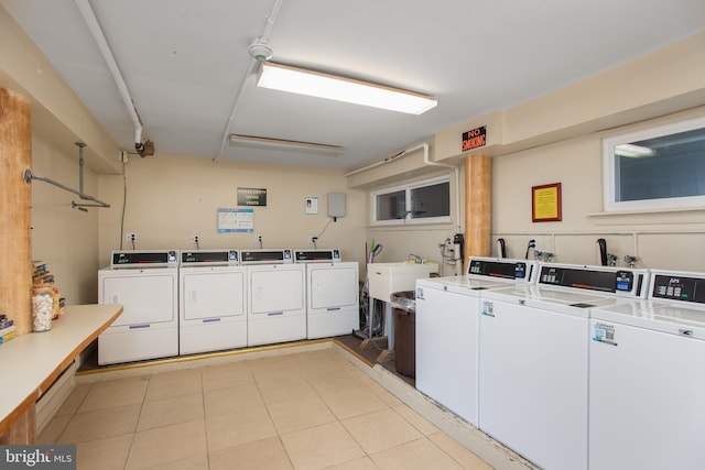 community laundry with washing machine and dryer and light tile patterned floors