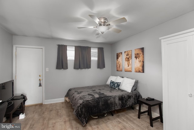 bedroom with light wood-style floors, baseboards, and ceiling fan