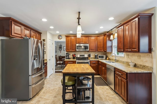 kitchen with stainless steel appliances, a sink, butcher block countertops, recessed lighting, and decorative backsplash