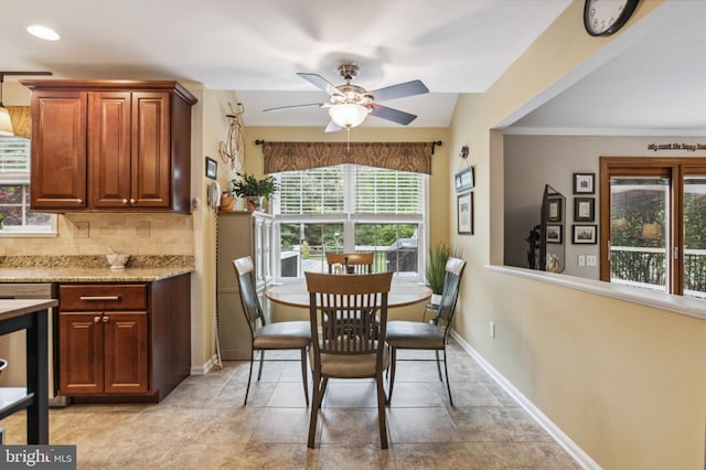 dining space with ceiling fan and baseboards