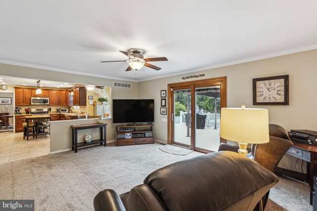 living room with ceiling fan, ornamental molding, and light colored carpet
