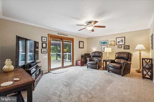 carpeted living area with a ceiling fan, crown molding, and baseboards
