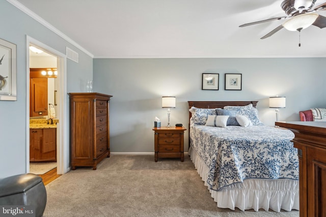 bedroom with ornamental molding, light colored carpet, baseboards, connected bathroom, and a ceiling fan