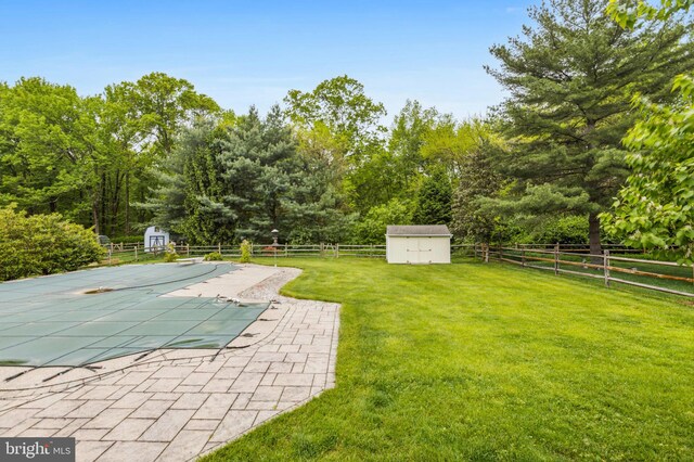 view of swimming pool featuring a storage unit, an outdoor structure, and a patio