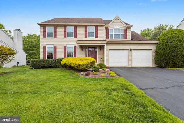 view of front facade with driveway, a front lawn, and an attached garage