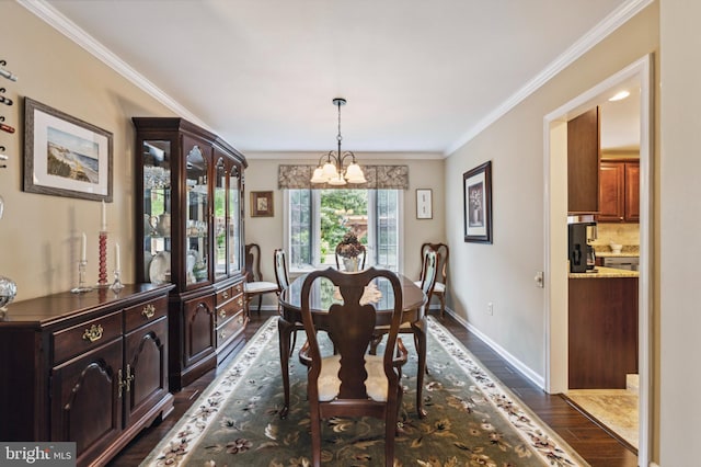 dining room featuring a chandelier, dark wood-style floors, ornamental molding, and baseboards