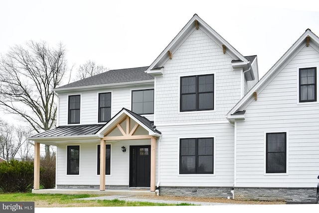 view of front facade with a standing seam roof, covered porch, and metal roof