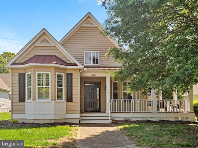 30106 Pelican Beach Cir, Dagsboro, DE 19939 - view of front of home featuring a standing seam roof, a porch, metal roof, and a front lawn