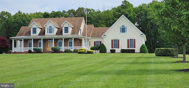 cape cod-style house featuring covered porch and a front yard
