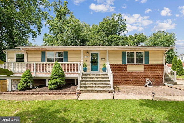 5728 Sunbury Dr, Alexandria, VA 22303 - view of front facade featuring stairway, a porch, brick siding, and a front yard