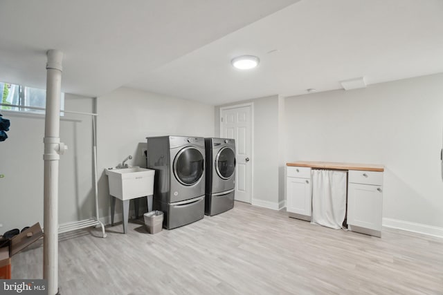 5728 Sunbury Dr, Alexandria, VA 22303 - laundry area with washing machine and dryer, cabinet space, light wood-type flooring, and baseboards