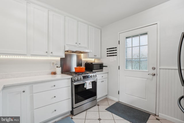5728 Sunbury Dr, Alexandria, VA 22303 - kitchen with appliances with stainless steel finishes, under cabinet range hood, white cabinetry, light countertops, and light tile patterned flooring