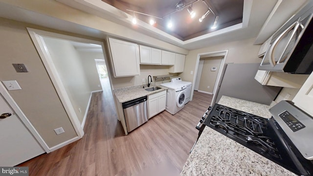 10239 Prince Pl Unit 26-T1, Upper Marlboro, MD 20774 - kitchen featuring stainless steel appliances, a raised ceiling, washer / clothes dryer, light wood finished floors, and white cabinets
