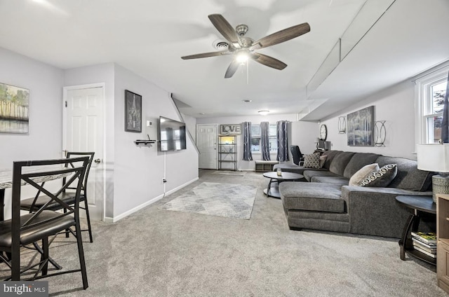 carpeted living room featuring a ceiling fan and baseboards