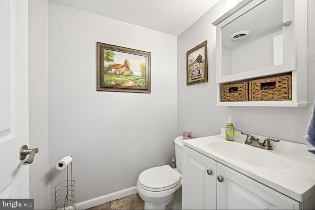 bathroom featuring vanity, toilet, and baseboards