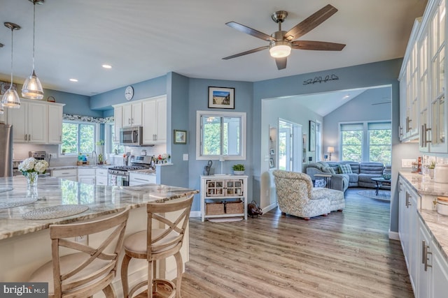 kitchen with stainless steel appliances, open floor plan, white cabinets, ceiling fan, and recessed lighting