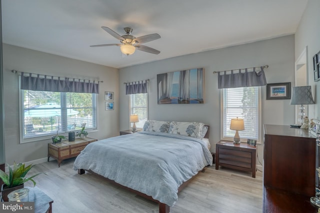bedroom featuring light wood-style floors, baseboards, and a ceiling fan