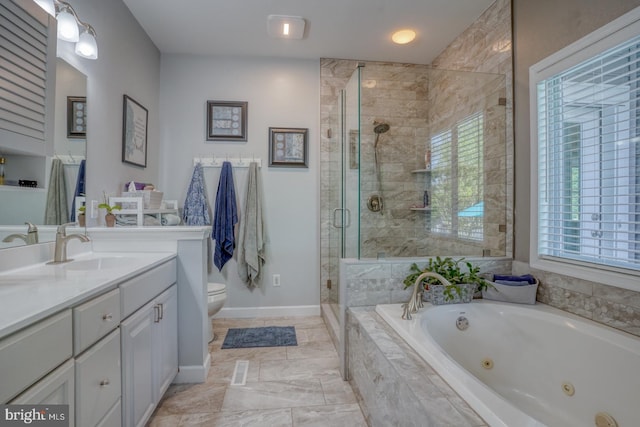 bathroom with a jetted tub, a stall shower, vanity, toilet, and baseboards