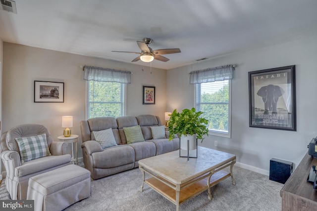 living area with plenty of natural light, ceiling fan, carpet flooring, and baseboards