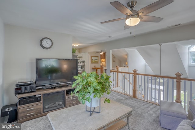 carpeted living area with ceiling fan