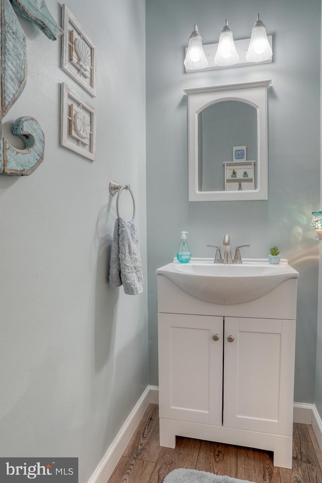 bathroom featuring vanity, wood finished floors, and baseboards
