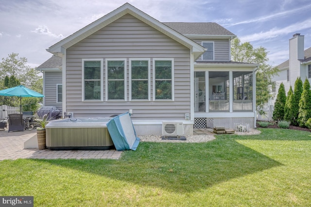 back of property featuring a hot tub, a patio area, a sunroom, ac unit, and a lawn