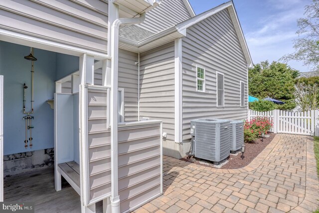 view of patio / terrace featuring central AC, fence, and a gate