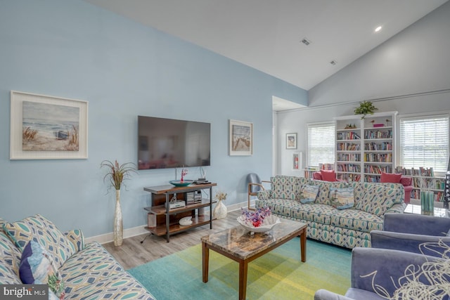 living room with high vaulted ceiling, wood finished floors, plenty of natural light, baseboards, and recessed lighting