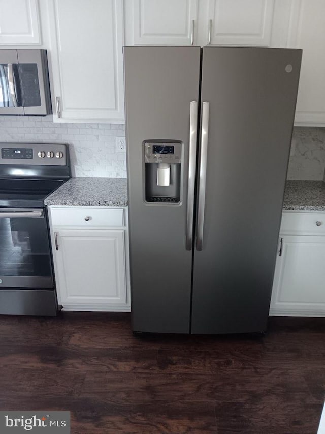 5991 Schooner Cir, King George, VA 22485 - kitchen with appliances with stainless steel finishes, decorative backsplash, white cabinets, light stone counters, and dark wood-style flooring
