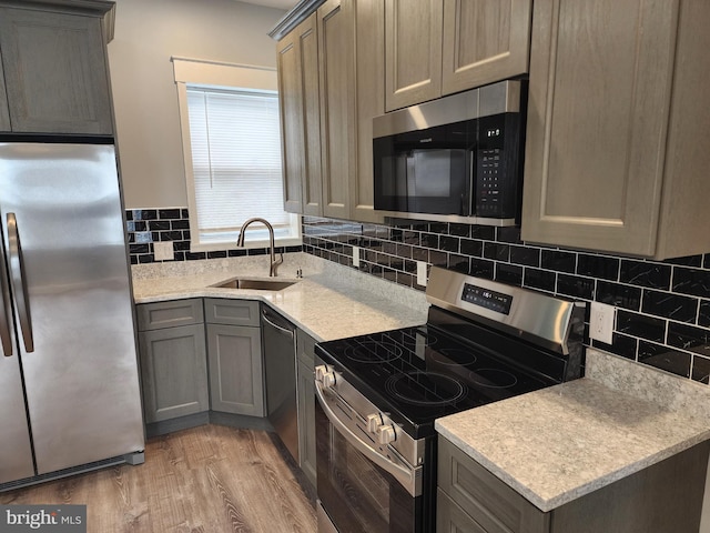5335 W Girard Ave, Philadelphia, PA 19131 - kitchen featuring appliances with stainless steel finishes, a sink, light wood-type flooring, gray cabinets, and backsplash