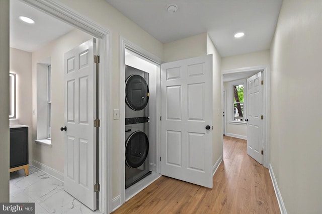 washroom featuring stacked washer / drying machine, baseboards, and recessed lighting