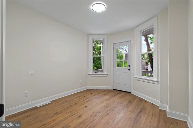 doorway to outside featuring wood finished floors and baseboards