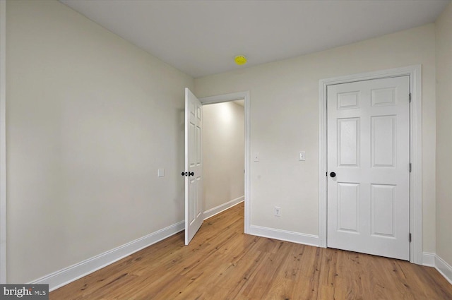 unfurnished bedroom with light wood-style flooring and baseboards