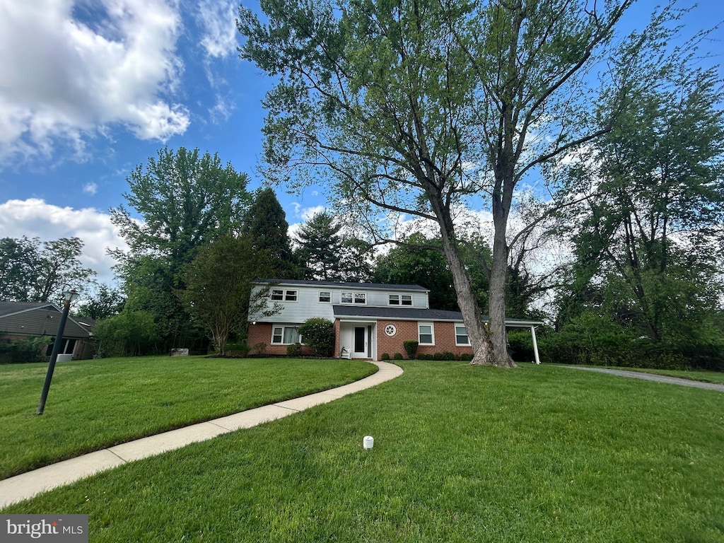 view of front of property featuring brick siding and a front yard