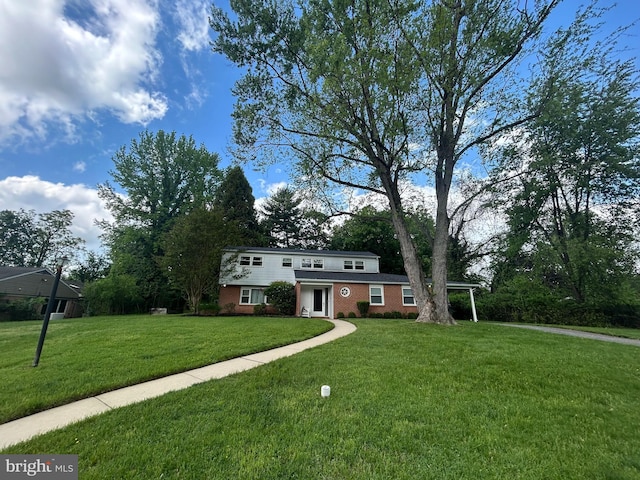 view of front of property featuring brick siding and a front yard