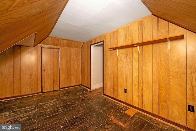 additional living space with wood walls and vaulted ceiling