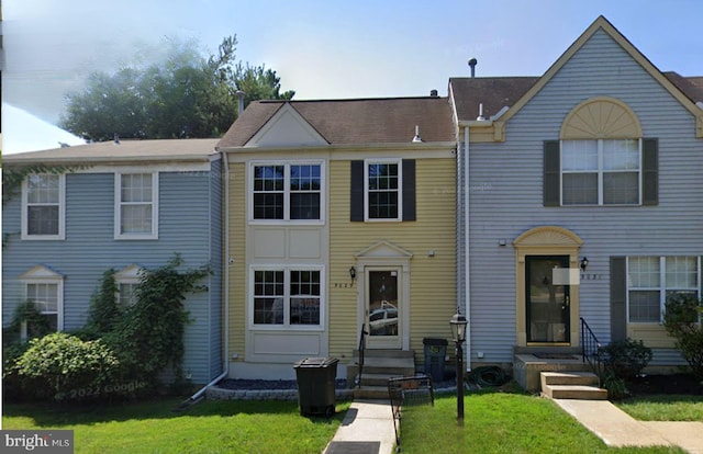 townhome / multi-family property with a front lawn
