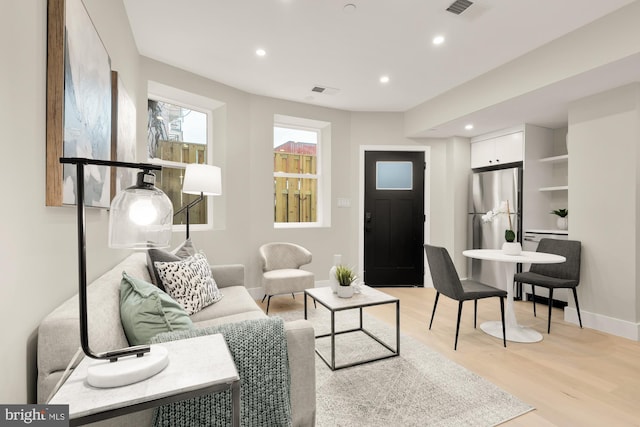living room with recessed lighting, light wood-style flooring, and baseboards