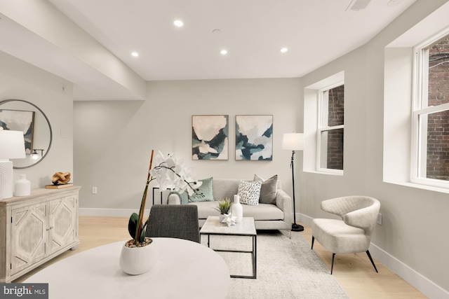 living room with light wood-type flooring, recessed lighting, and baseboards