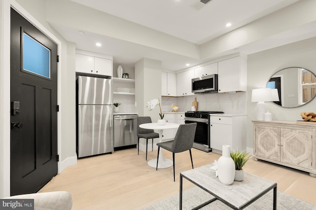 kitchen with stainless steel appliances, open shelves, backsplash, recessed lighting, and white cabinetry