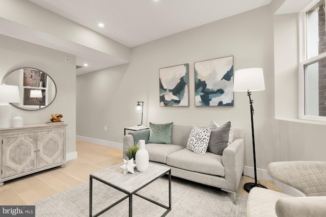 living room with baseboards, light wood finished floors, and recessed lighting