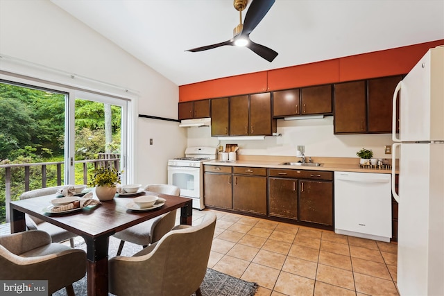 kitchen featuring white appliances, vaulted ceiling, under cabinet range hood, a sink, and light tile patterned flooring