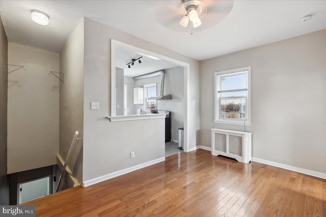 1331 Mifflin St, Philadelphia, PA 19148 - unfurnished dining area with radiator, hardwood / wood-style floors, ceiling fan, baseboards, and rail lighting