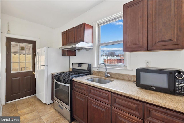 1331 Mifflin St, Philadelphia, PA 19148 - kitchen with stainless steel gas range oven, a sink, black microwave, under cabinet range hood, and light stone countertops