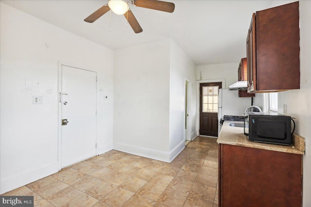 1331 Mifflin St, Philadelphia, PA 19148 - kitchen featuring under cabinet range hood, ceiling fan, light countertops, baseboards, and stone finish flooring